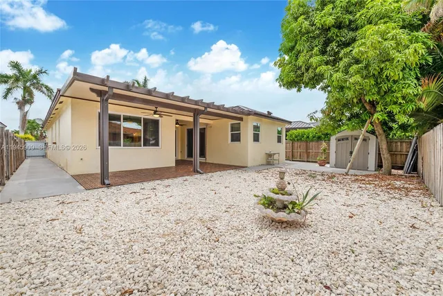 a white house with a large tree in the background