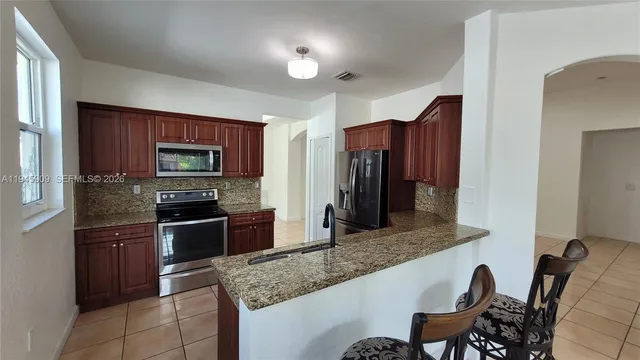 a kitchen with granite countertop stainless steel appliances and wooden cabinets