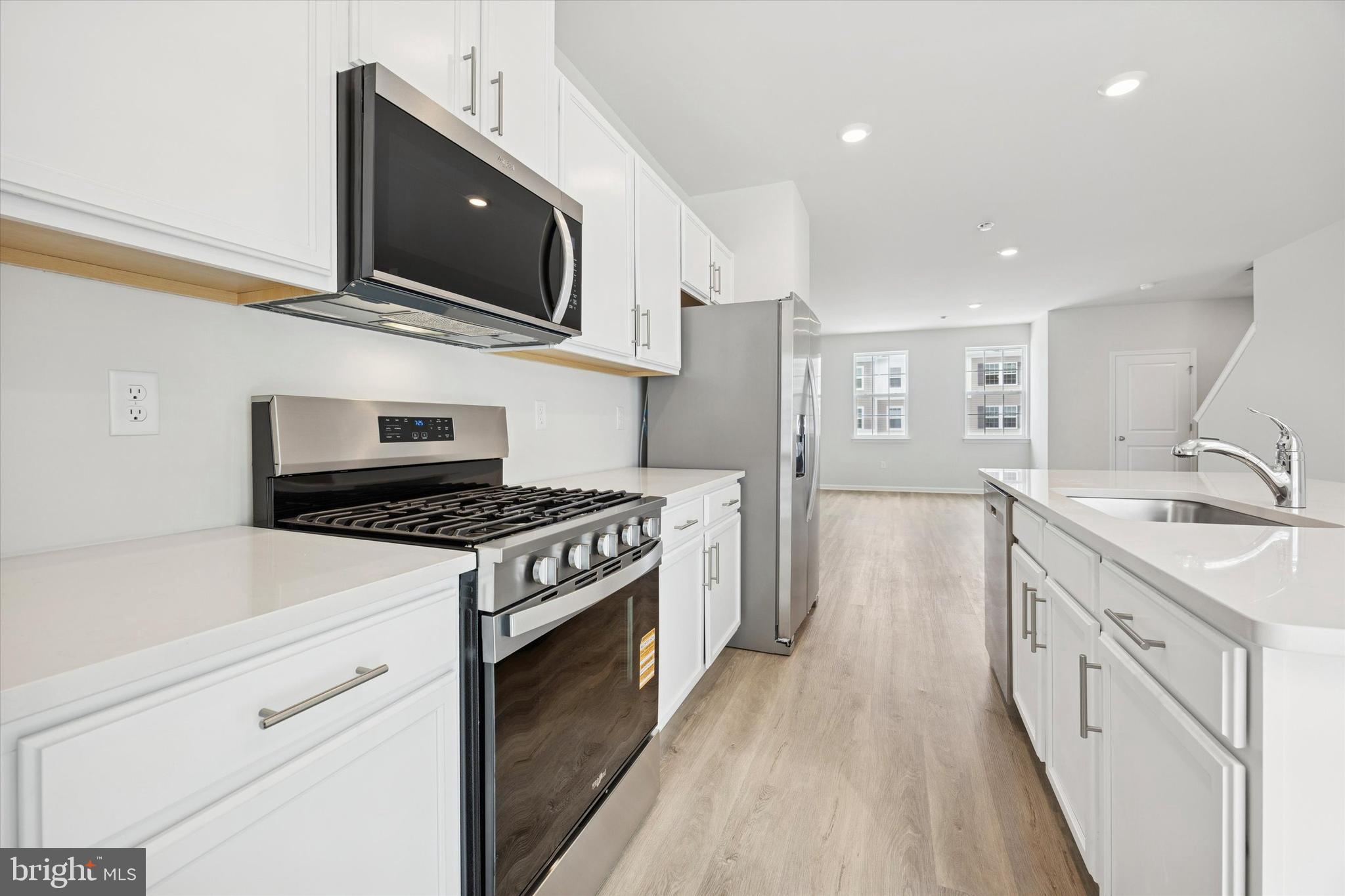 163 Sandy Rdg Road Sicklerville, NJ 08081 - Photo 12 of 30 a kitchen with stainless steel appliances a sink dishwasher a stove and a microwave oven with wooden floor