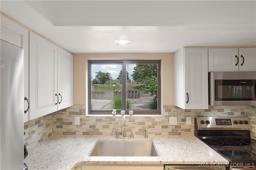 24 East Casa Del Rio, Unit 689 Lake Ozark, MO 65049 - Photo 11 of 31 Kitchen sink with beautiful back splash & window f