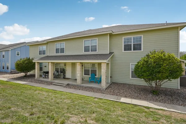 a view of a house with a yard and sitting area