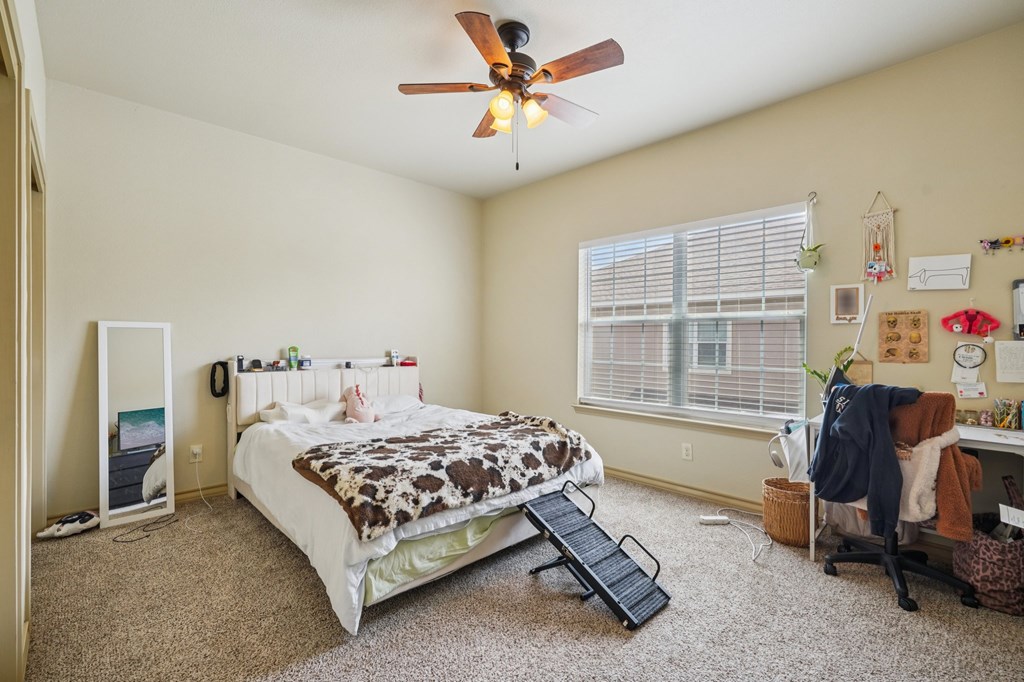 2312 Sailing Way Kerrville, TX 78028 - Photo 32 of 60 a bedroom with a bed a table and a chandelier
