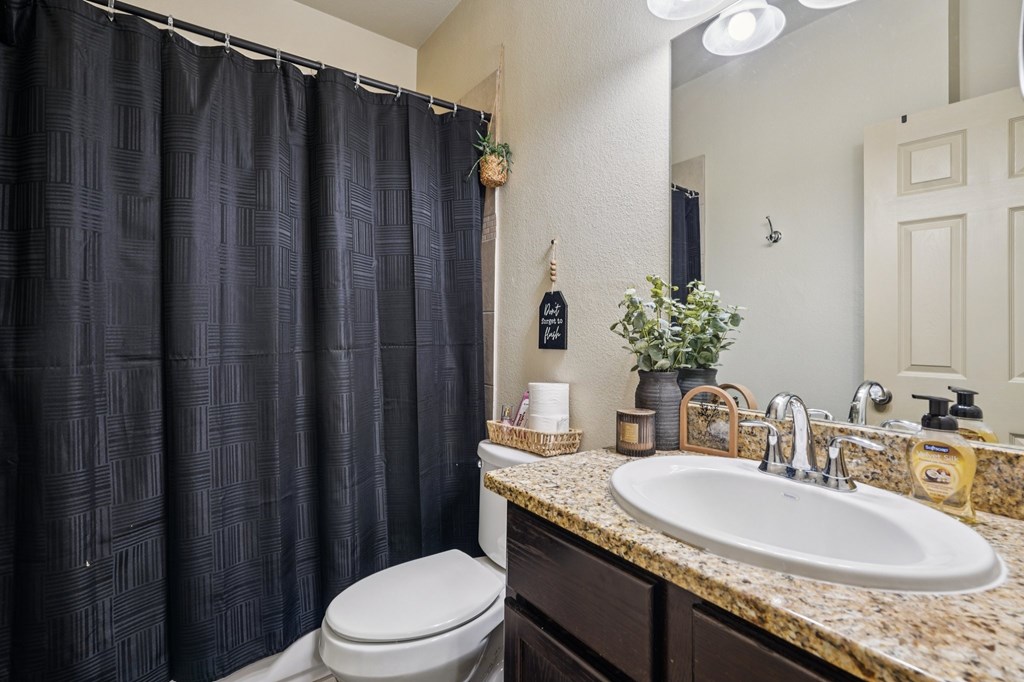 2312 Sailing Way Kerrville, TX 78028 - Photo 38 of 60 a bathroom with a granite countertop sink toilet and mirror