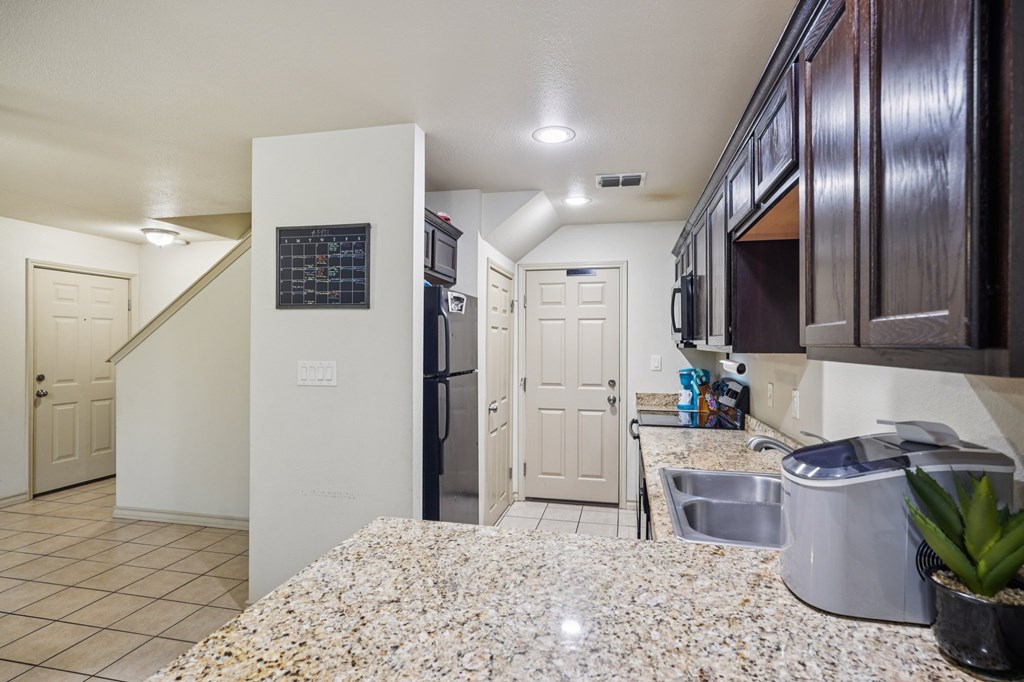 2312 Sailing Way Kerrville, TX 78028 - Photo 51 of 60 a kitchen with stainless steel appliances kitchen island granite countertop a refrigerator and a sink