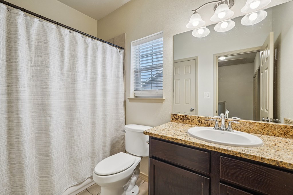 2312 Sailing Way Kerrville, TX 78028 - Photo 57 of 60 a bathroom with a granite countertop sink a toilet and a mirror