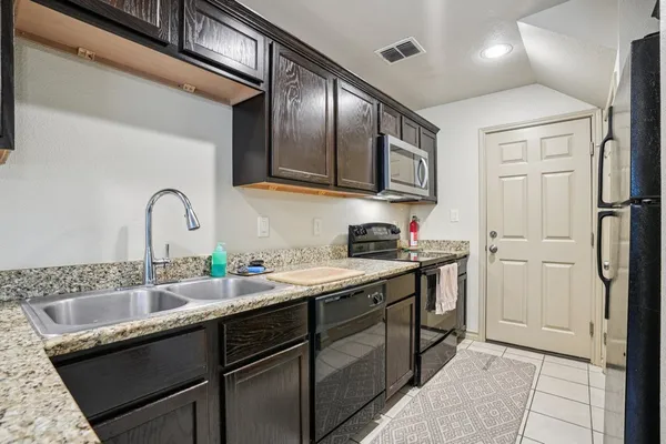 a kitchen with a sink cabinets and stainless steel appliances