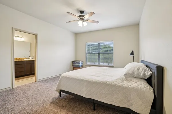 a bedroom with a large bed and a chandelier