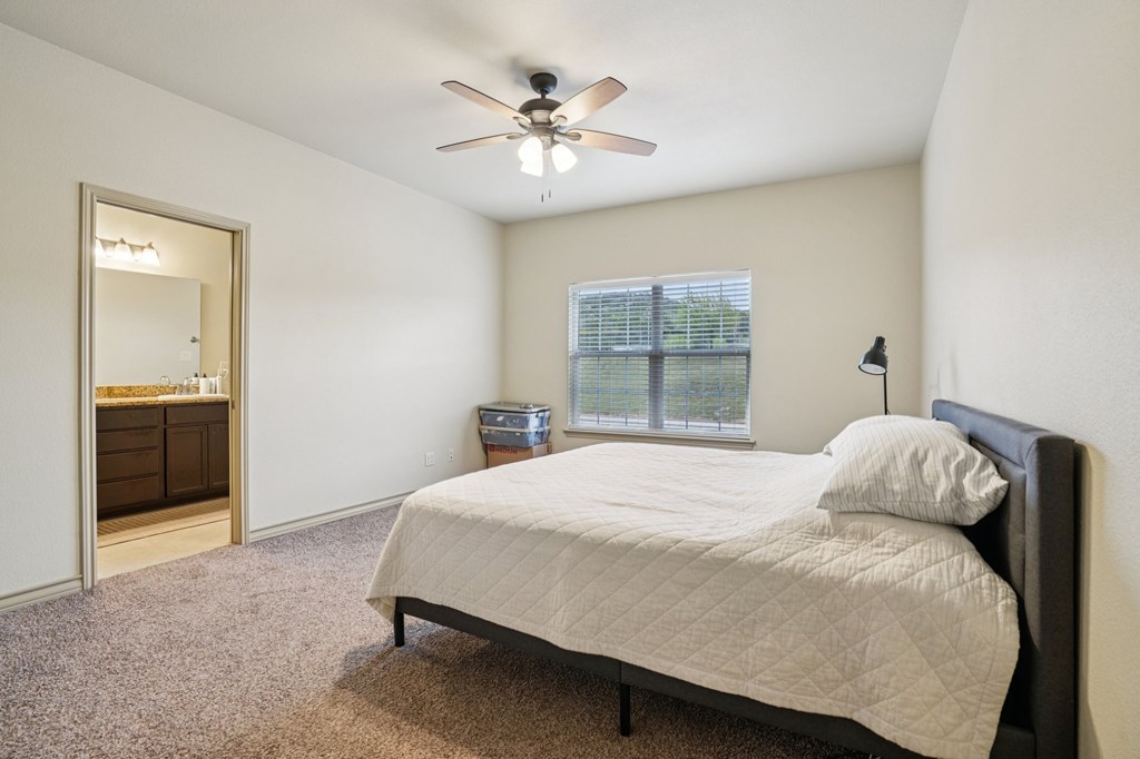 2312 Sailing Way Kerrville, TX 78028 - Photo 10 of 60 a bedroom with a large bed and a chandelier