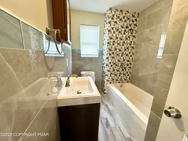 a bathroom with a sink a toilet and shower