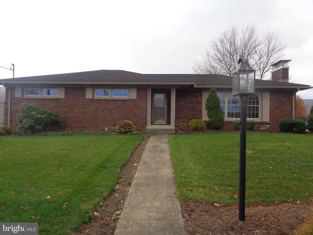 a front view of a house with a garden and yard