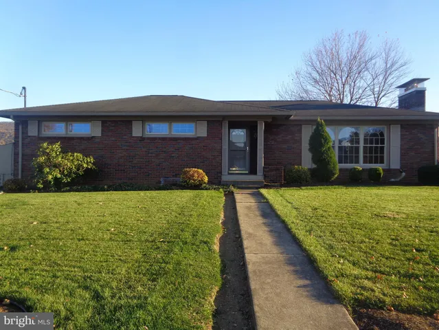 a front view of a house with a yard and potted plants