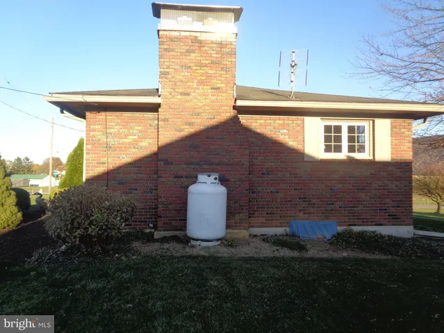 a view of a backyard with plants and brick wall