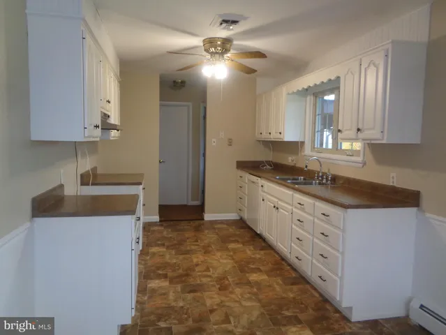 a kitchen with granite countertop a sink a stove and cabinets