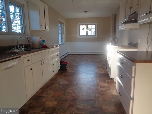 a kitchen with granite countertop a stove a sink and a refrigerator