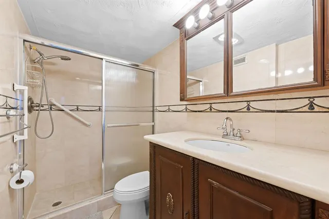 a bathroom with a sink vanity mirror and toilet