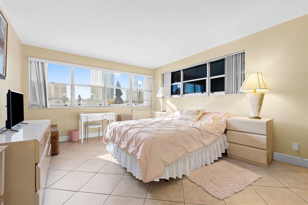 111 Golden Isles Drive, Unit B2 Hallandale Beach, FL 33009 - Photo 8 of 12 a bedroom with bed and a large window