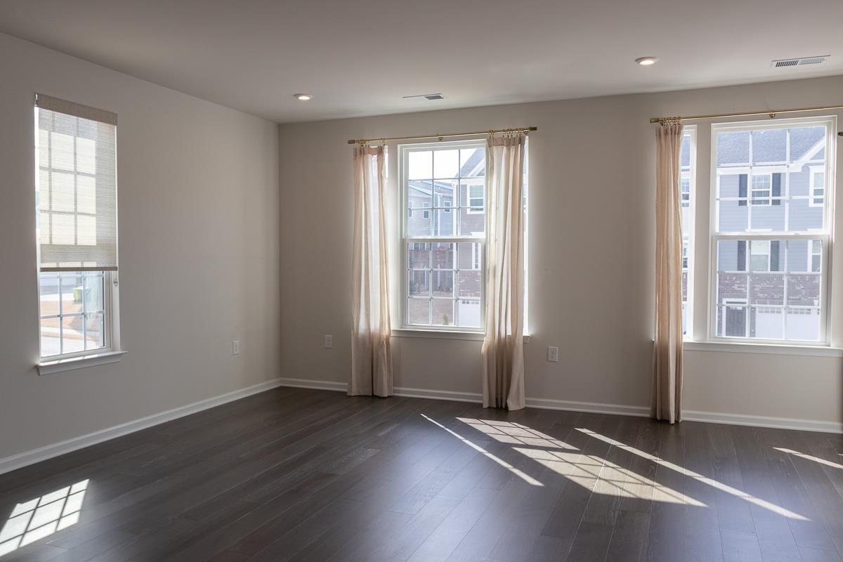4847 Randall Road Durham, NC 27707 - Photo 2 of 25 a view of an empty room with wooden floor and a window
