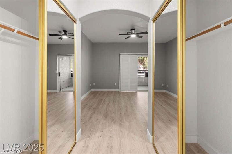 3320 South Fort Apache Road, Unit 125 Las Vegas, NV 89117 - Photo 21 of 26 Golden mirrored closet doors frame a bright room with light wood-style flooring and arched entryway.