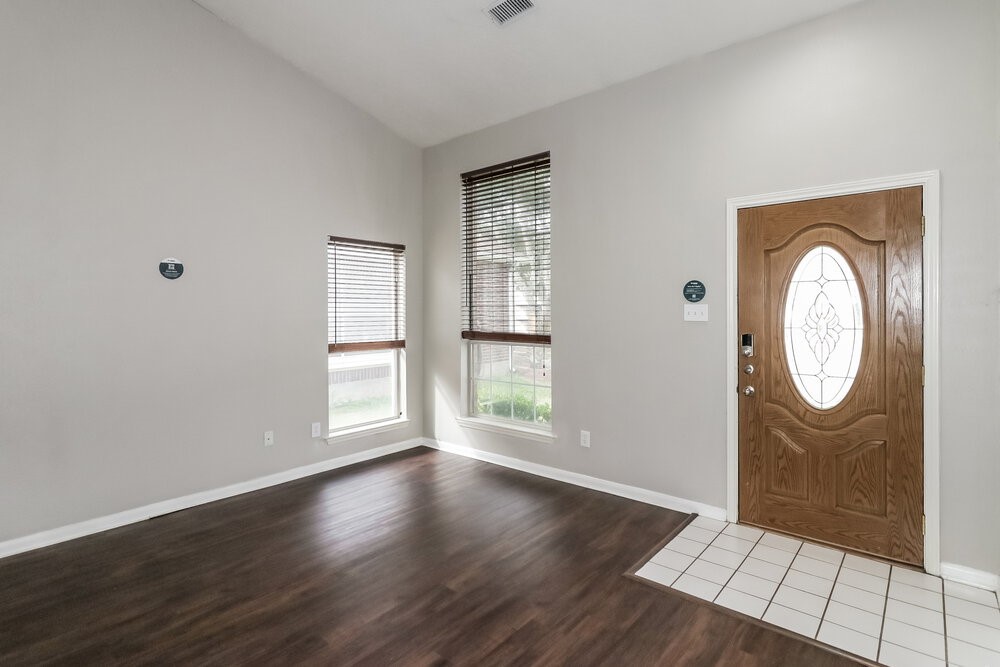 19823 Indian Cherry Forest Lane Cypress, TX 77433 - Photo 4 of 16 an empty room with wooden floor mirror and windows