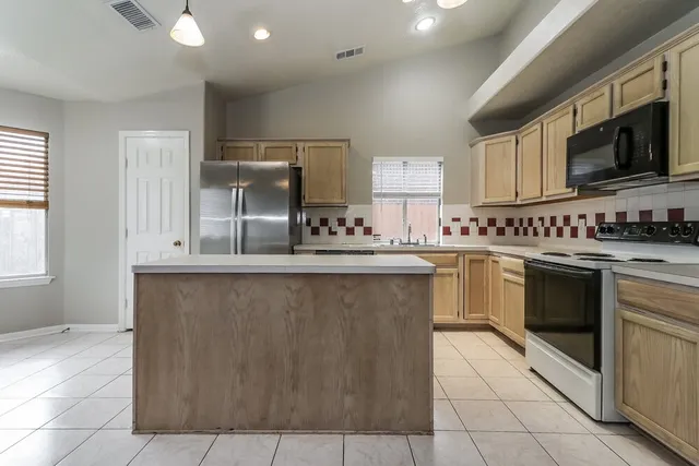 a kitchen with stainless steel appliances a sink stove and cabinets