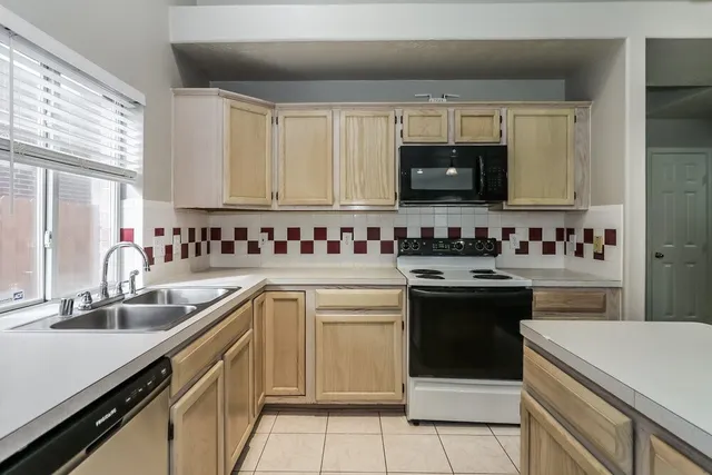 a kitchen with a sink stove top oven and cabinets