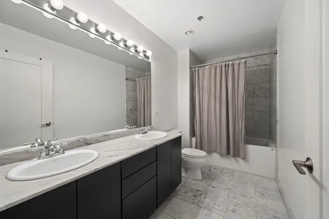 a bathroom with a double vanity sink mirror and toilet
