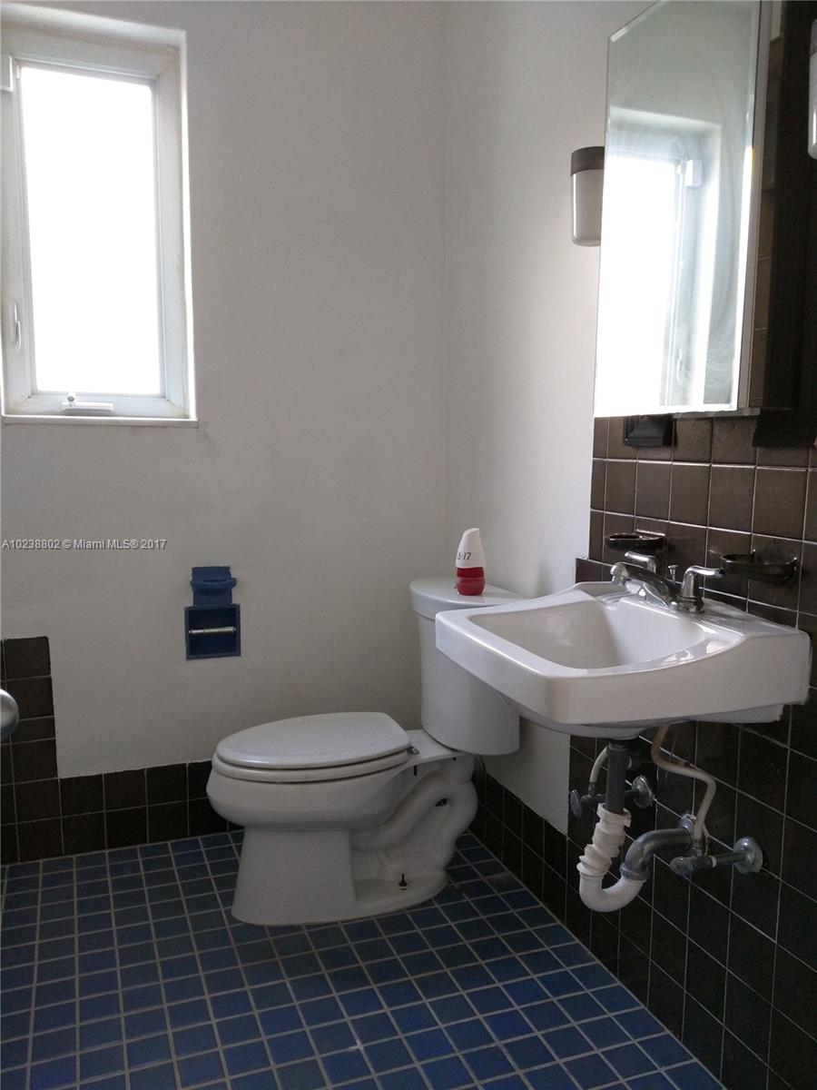 4717 Alton Road Miami Beach, FL 33140 - Photo 11 of 34 a bathroom with a sink toilet and mirror