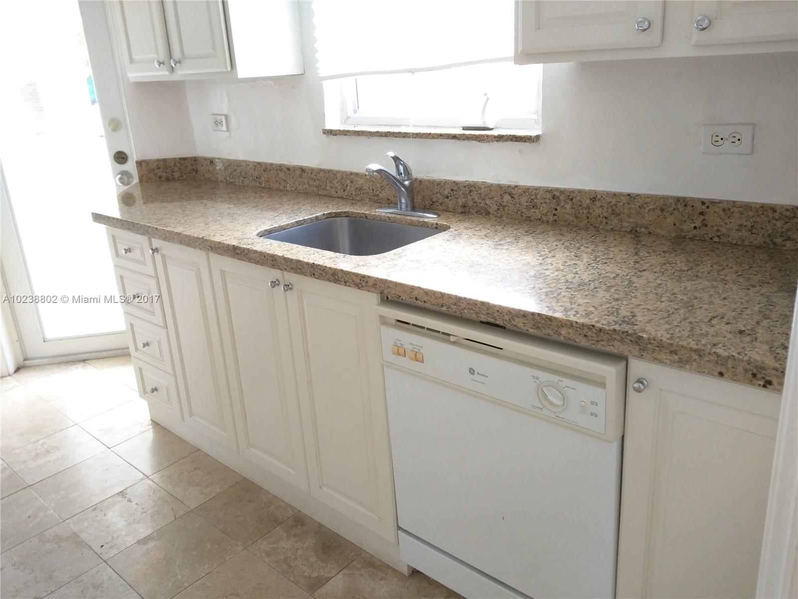 4717 Alton Road Miami Beach, FL 33140 - Photo 6 of 34 a kitchen with a sink and cabinets