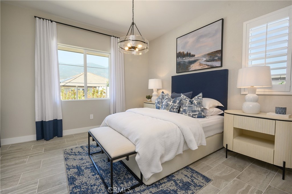 13093 Edgware Drive Rancho Cucamonga, CA 91739 - Photo 9 of 25 a bedroom with a bed and a chandelier