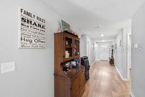 11014 Golden Warbler Road Brooksville, FL 34613 - Photo 16 of 50 a view of a hallway with furniture and wooden floor