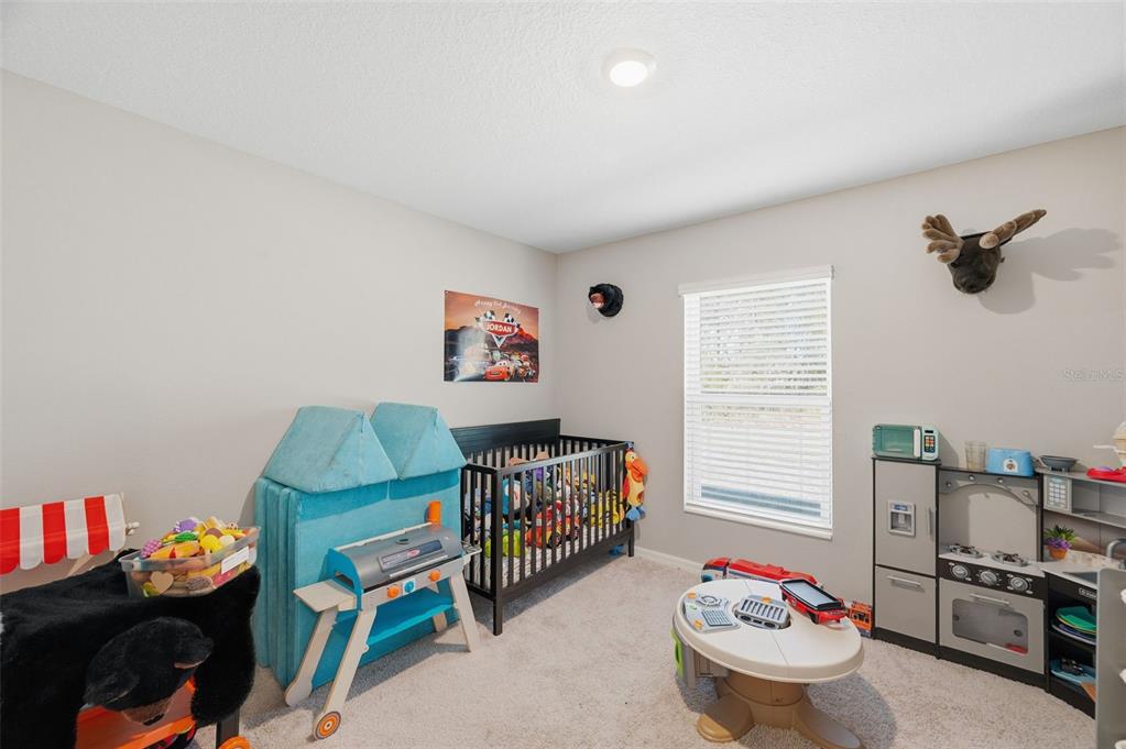 11014 Golden Warbler Road Brooksville, FL 34613 - Photo 24 of 50 a bedroom with furniture and a wooden floor