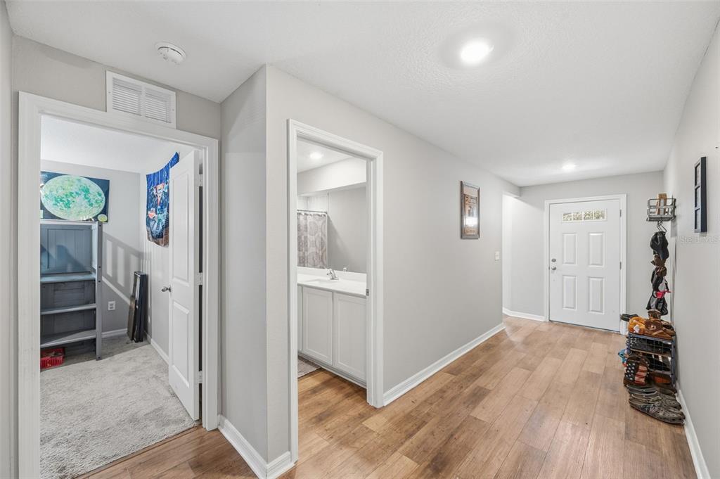 11014 Golden Warbler Road Brooksville, FL 34613 - Photo 27 of 50 a view of a hallway with bathroom and wooden floor