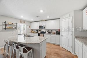11014 Golden Warbler Road Brooksville, FL 34613 - Photo 4 of 50 a kitchen with a sink a stove a refrigerator cabinets and chairs