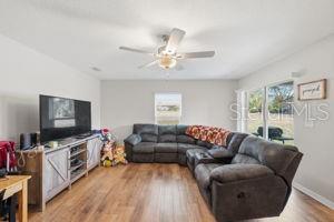 11014 Golden Warbler Road Brooksville, FL 34613 - Photo 8 of 50 a living room with furniture and a flat screen tv