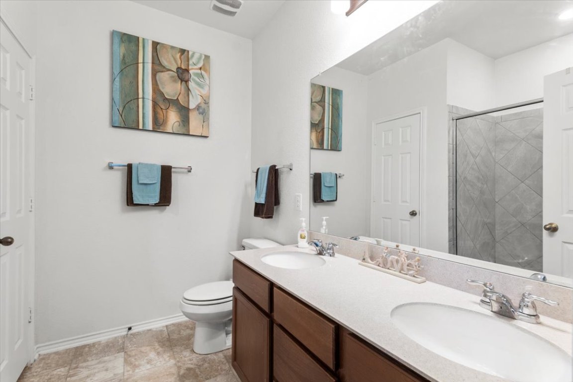 239 Crimson Lane Kyle, TX 78640 - Photo 14 of 25 a bathroom with a toilet a sink and mirror