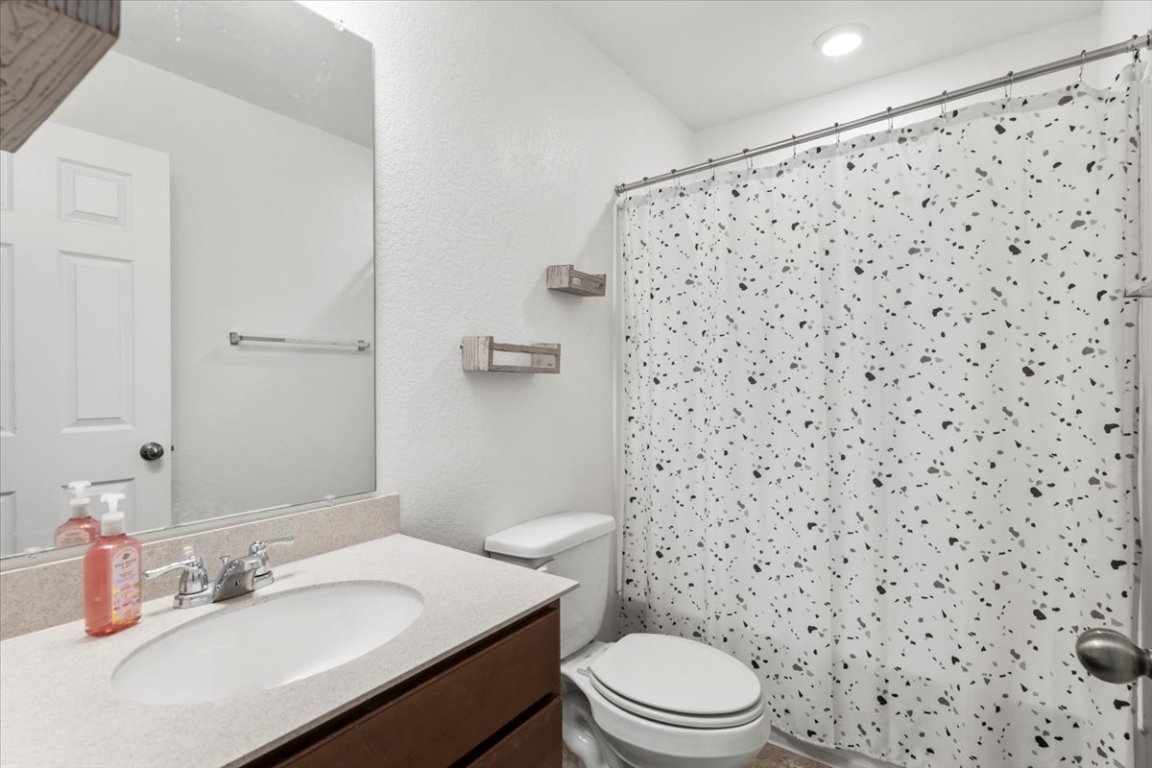 239 Crimson Lane Kyle, TX 78640 - Photo 18 of 25 a bathroom with a sink a toilet and shower curtain