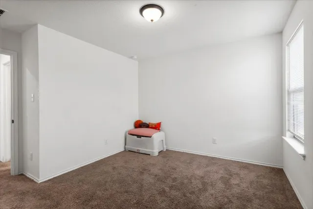 an empty room with a chandeliers fan