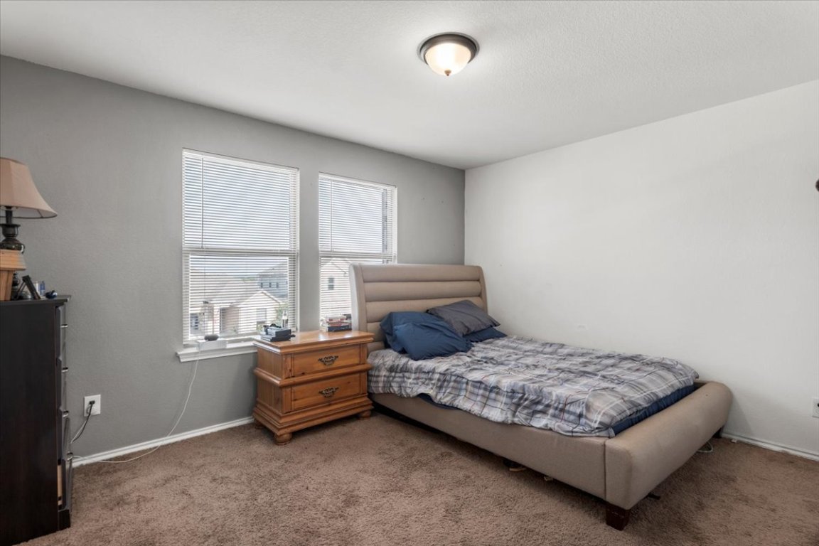 239 Crimson Lane Kyle, TX 78640 - Photo 22 of 25 a bedroom with a bed and window