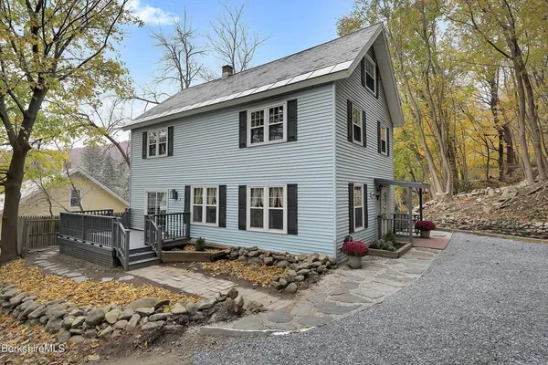 a front view of a house with a yard covered in snow