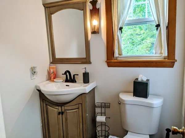 a bathroom with a toilet sink and mirror