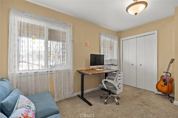 a view of a workspace with furniture and a window