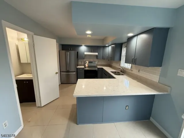 a large kitchen with a large counter top stainless steel appliances and cabinets