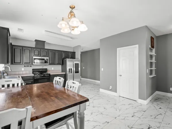 a kitchen with stainless steel appliances granite countertop a sink refrigerator stove and microwave