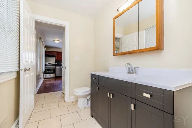 a spacious bathroom with a toilet sink and mirror