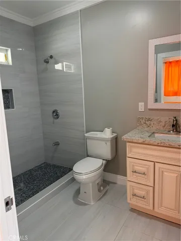 a bathroom with a granite countertop toilet a sink and a shower