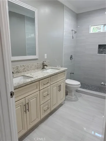 a bathroom with a granite countertop sink a toilet and a mirror