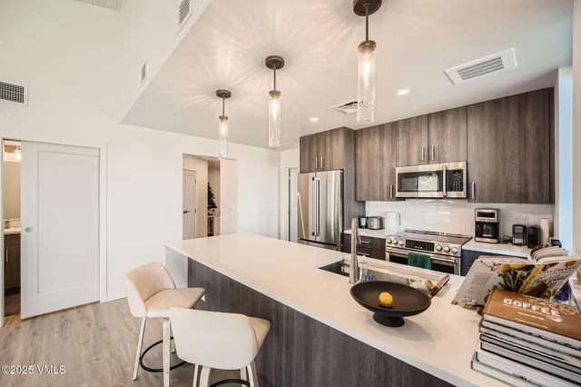a kitchen with a sink a stove and chairs