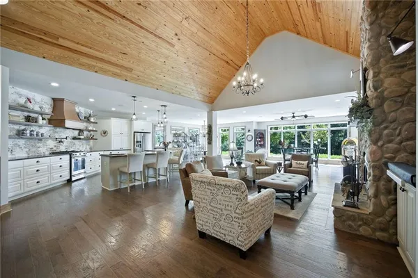 a kitchen with stainless steel appliances granite countertop a sink a stove and a wooden floors