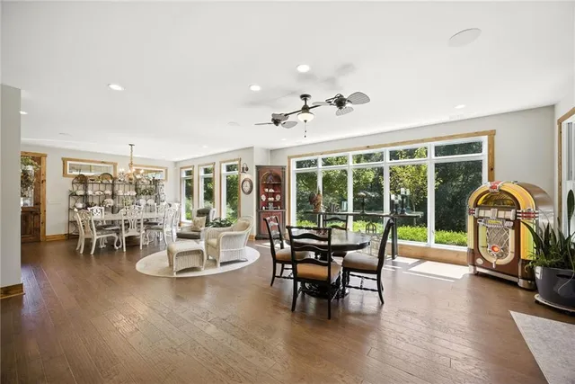 a kitchen with stainless steel appliances kitchen island granite countertop a stove a sink and white cabinets with wooden floor