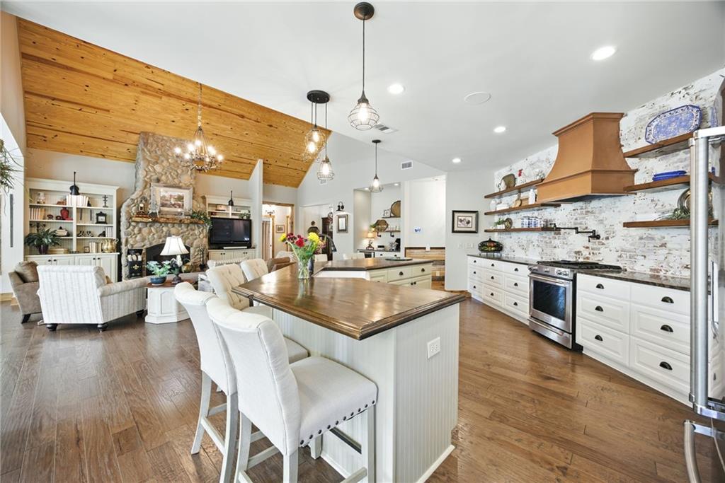 1620 Pond Fork Church Road Talmo, GA 30575 - Photo 24 of 73 a kitchen with stainless steel appliances kitchen island granite countertop a stove a sink and white cabinets with wooden floor